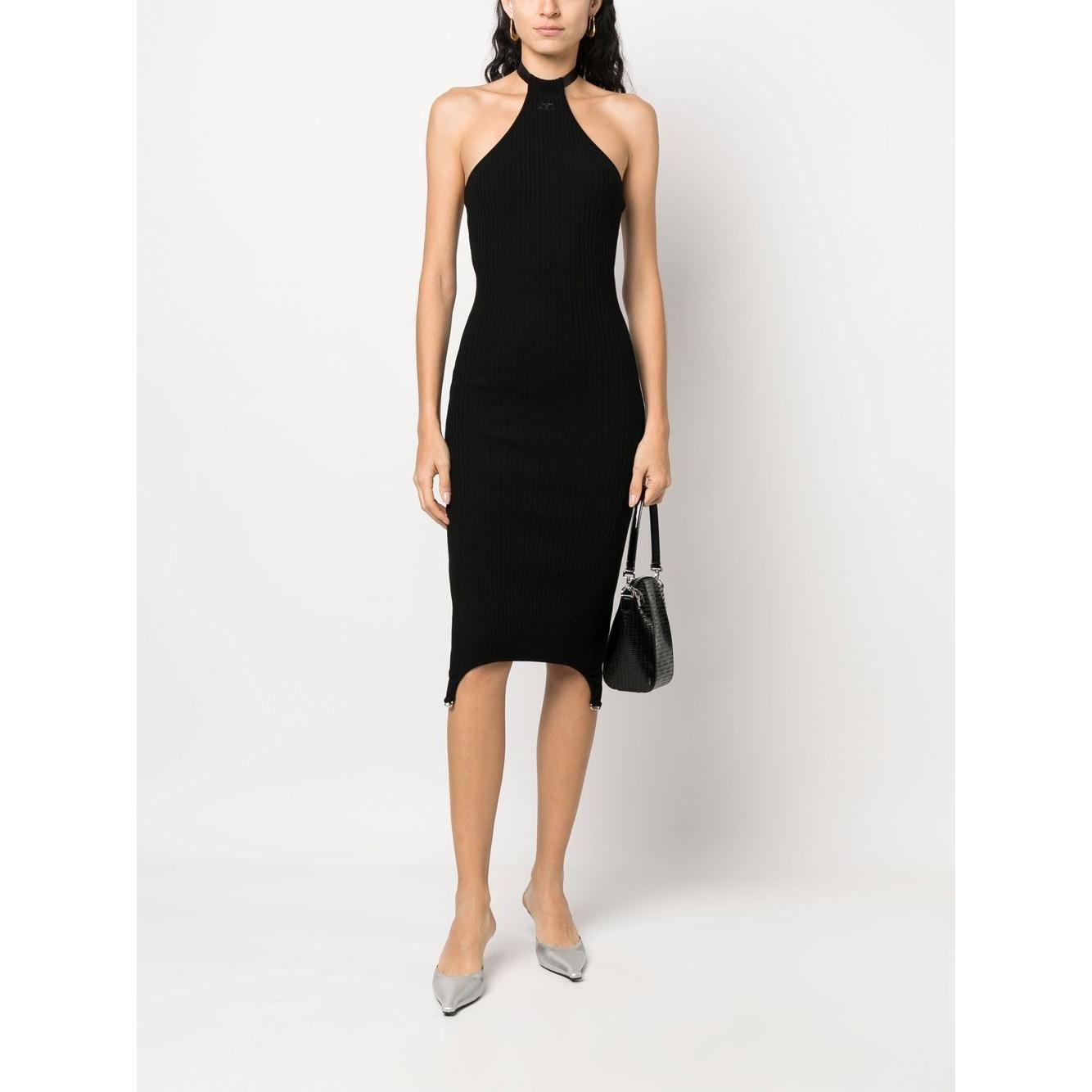 Woman wearing a black Courrèges halterneck bodycon dress with ribbed knit and embroidered logo, styled with a handbag and heels.