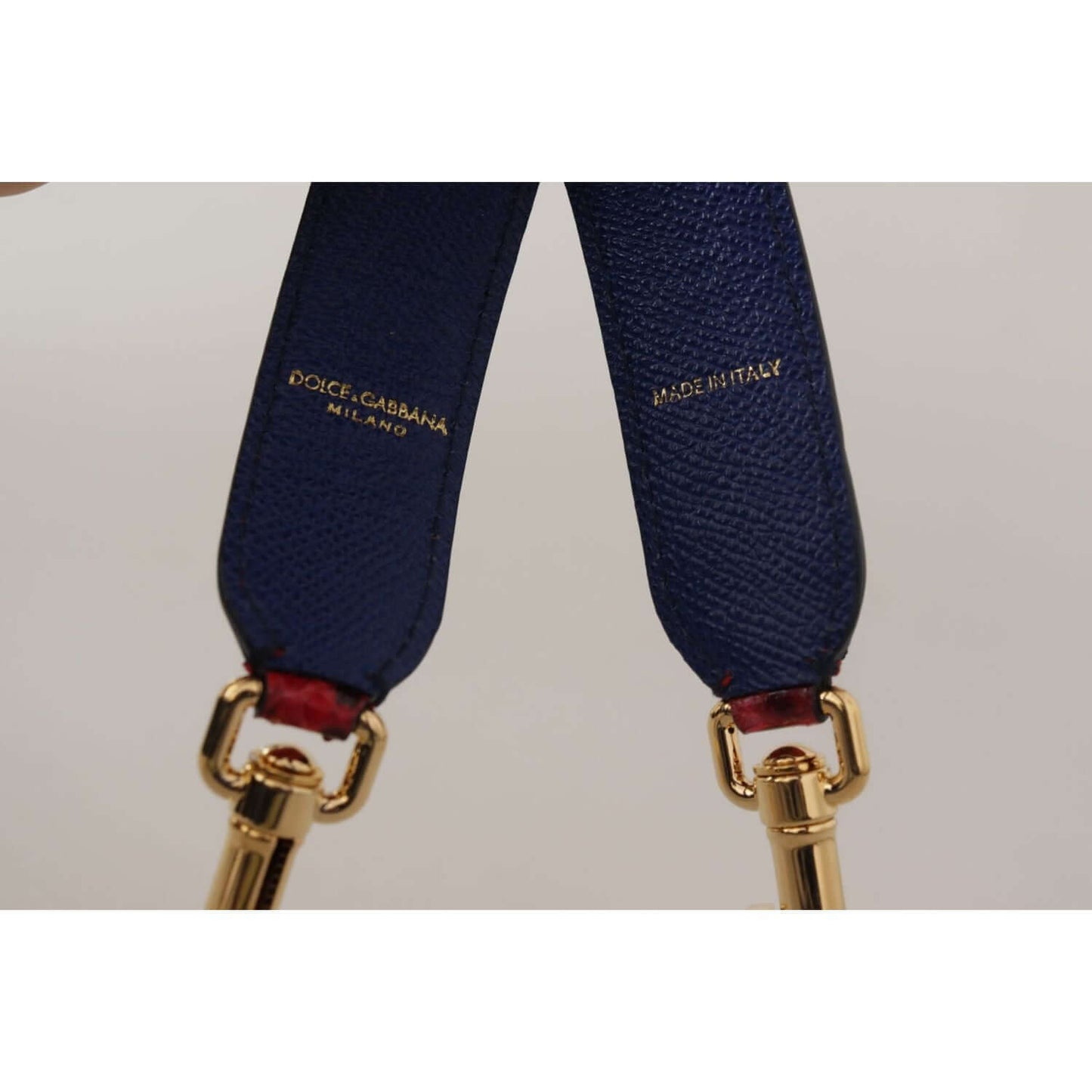 Close-up of Dolce & Gabbana blue leather strap with gold-tone lobster clasps, showing 'Made in Italy' and brand logo engravings.