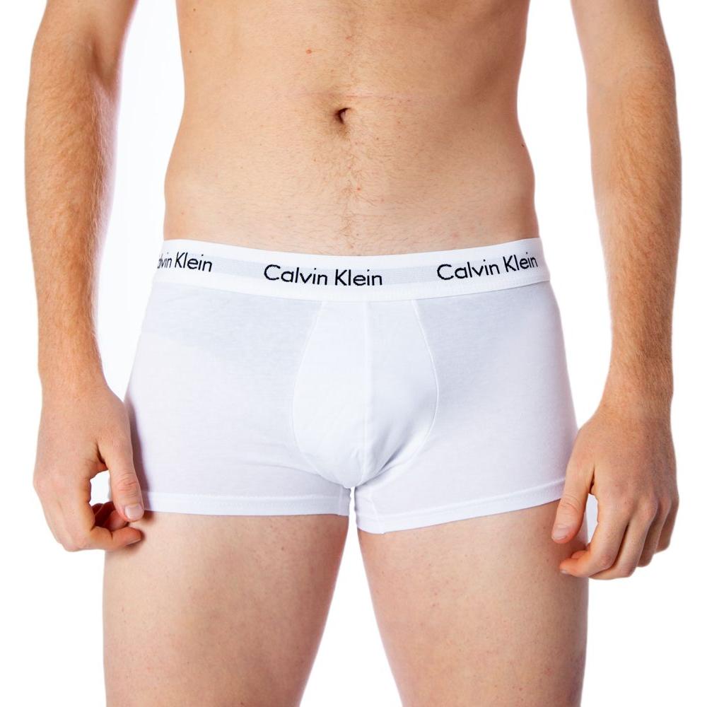 Man wearing white Calvin Klein boxer shorts with logo waistband, showcasing a comfortable fit and stylish design.