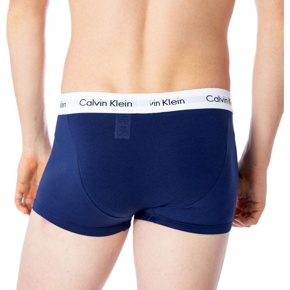 Model wearing blue Calvin Klein boxer shorts with logo waistband, showcasing back view and fit.