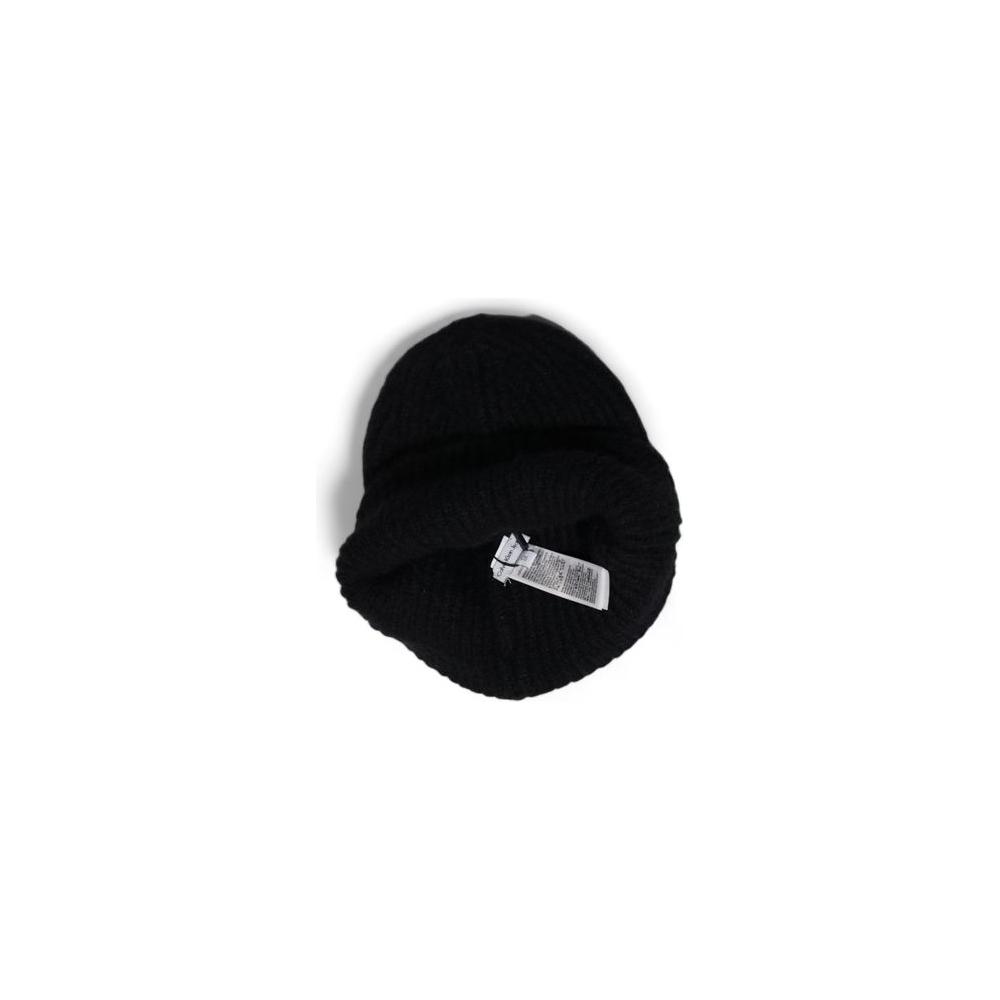 Top view of a black knit beanie with a label, showcasing a simple design on a white background.