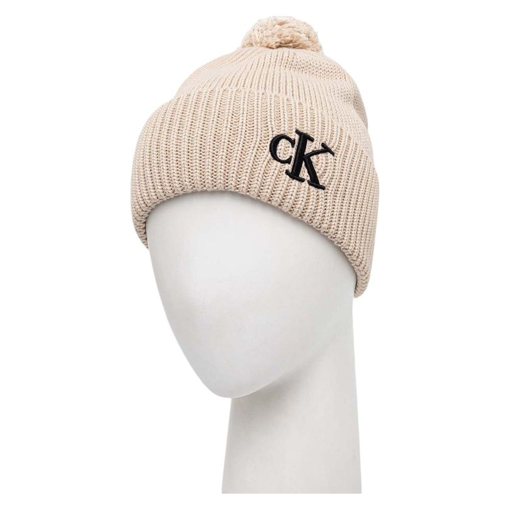 Calvin Klein beige cotton beanie hat with pom pom and embroidered 'cK' logo, perfect winter accessory for warmth and style.