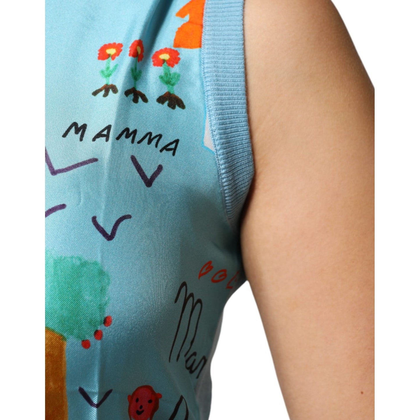 Close-up of blue Dolce & Gabbana cashmere sleeveless top with colorful drawings and text, highlighting unique design and texture.