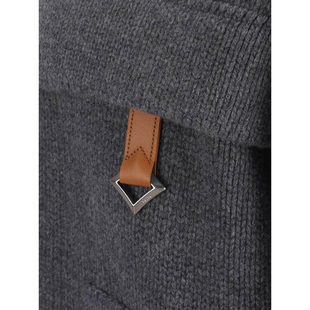 Close-up of MCM Collection Cardigan with brown leather accent on charcoal wool, featuring a ribbed texture and detailed stitching.