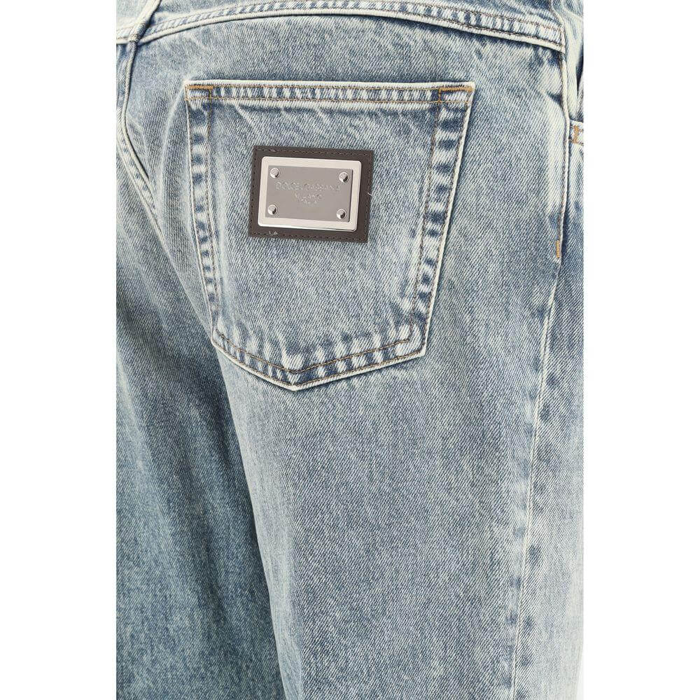 Back pocket detail of Dolce & Gabbana worn-effect jeans with metal logo patch and distressed denim look.