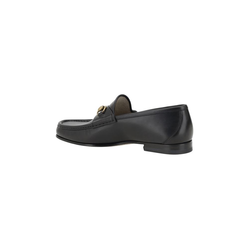 Gucci leather loafer with metallic horsebit detail, round toe, and leather block heel, showcasing elegant and sophisticated design.