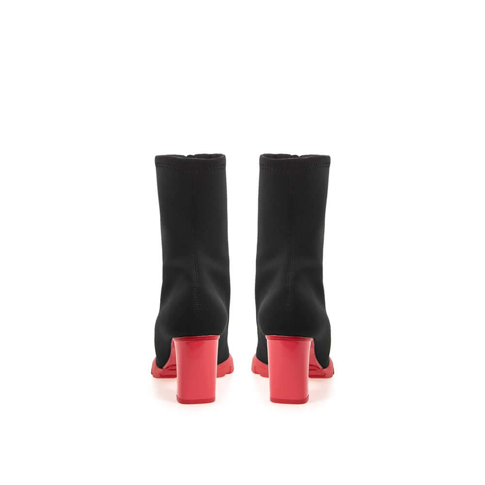 Rear view of Alexander McQueen black neoprene sock boots with red block heels and rubber soles.
