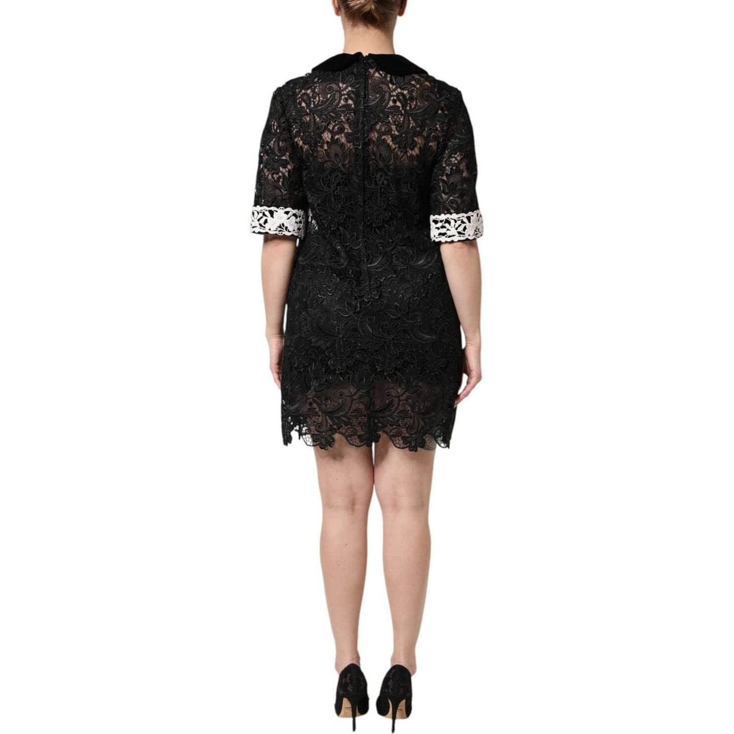Back view of Dolce & Gabbana black floral lace mini dress with embellishments, featuring zipper closure, on model.