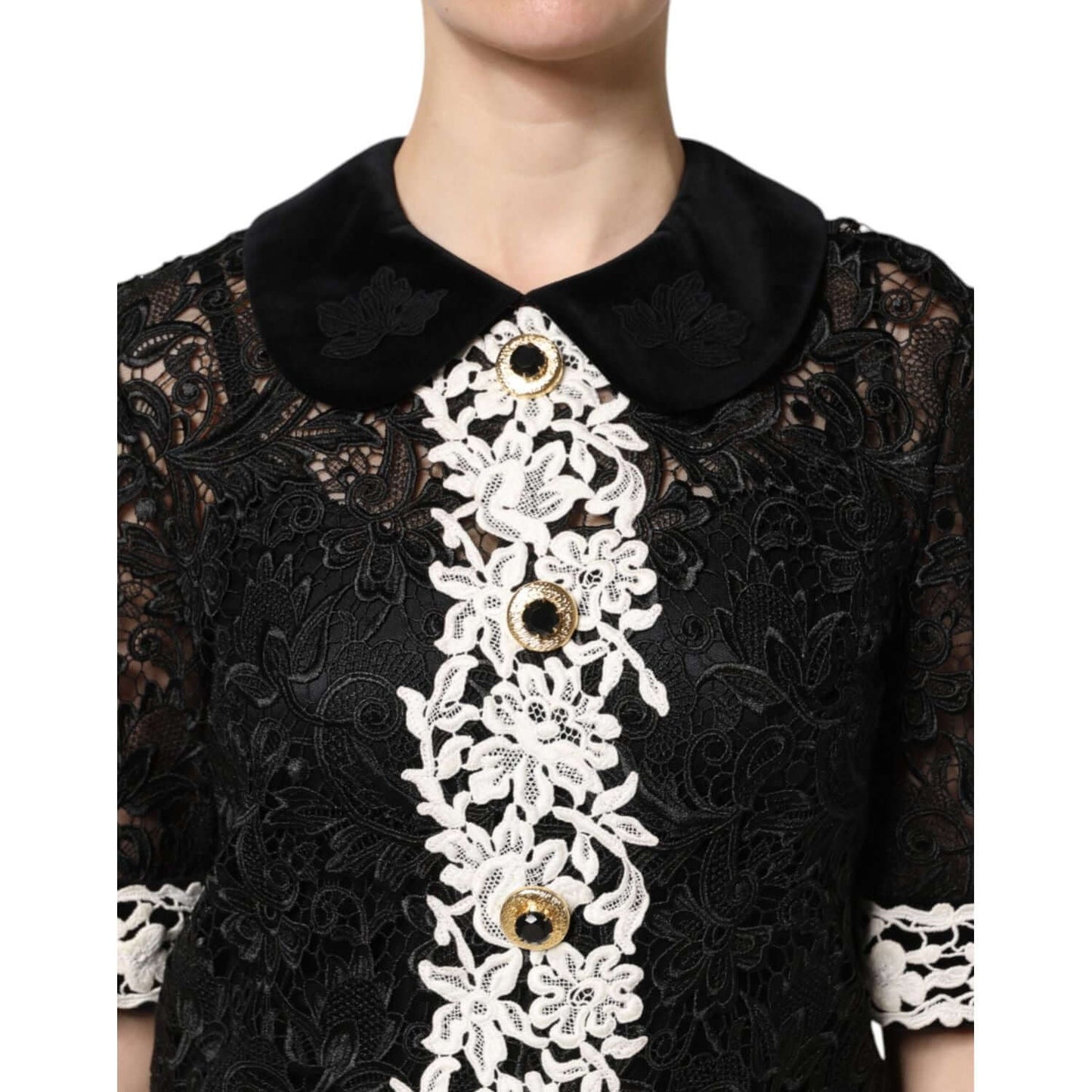 Dolce & Gabbana black floral lace embellished mini dress with gold buttons and white floral detailing, close-up view.