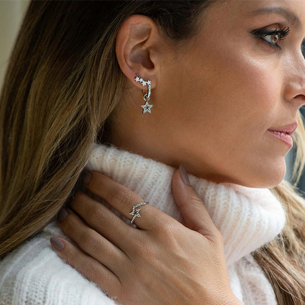 Woman wearing AN JEWELS JEWELRY Mod. ADC.R01SC-7 earrings and ring against a cozy sweater