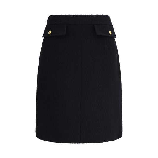 Chloé Black Wool Midi Skirt with front flap pockets and gold-tone buttons, crafted from bouclé wool for a structured fit.