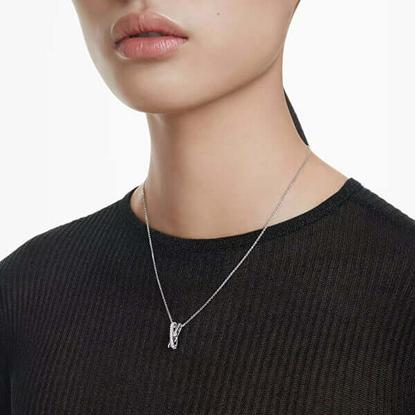 Woman wearing necklace with pendant on black top