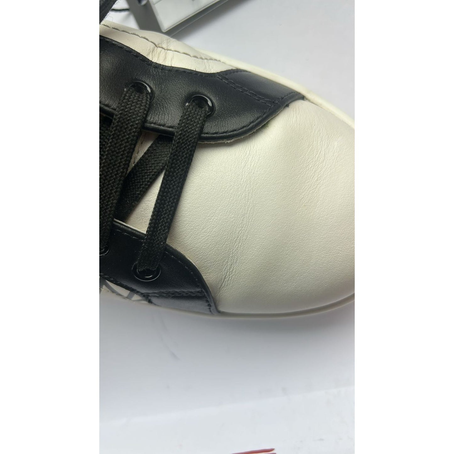 Close-up of Dolce & Gabbana white and black leather sneaker with black laces, showcasing Italian craftsmanship.