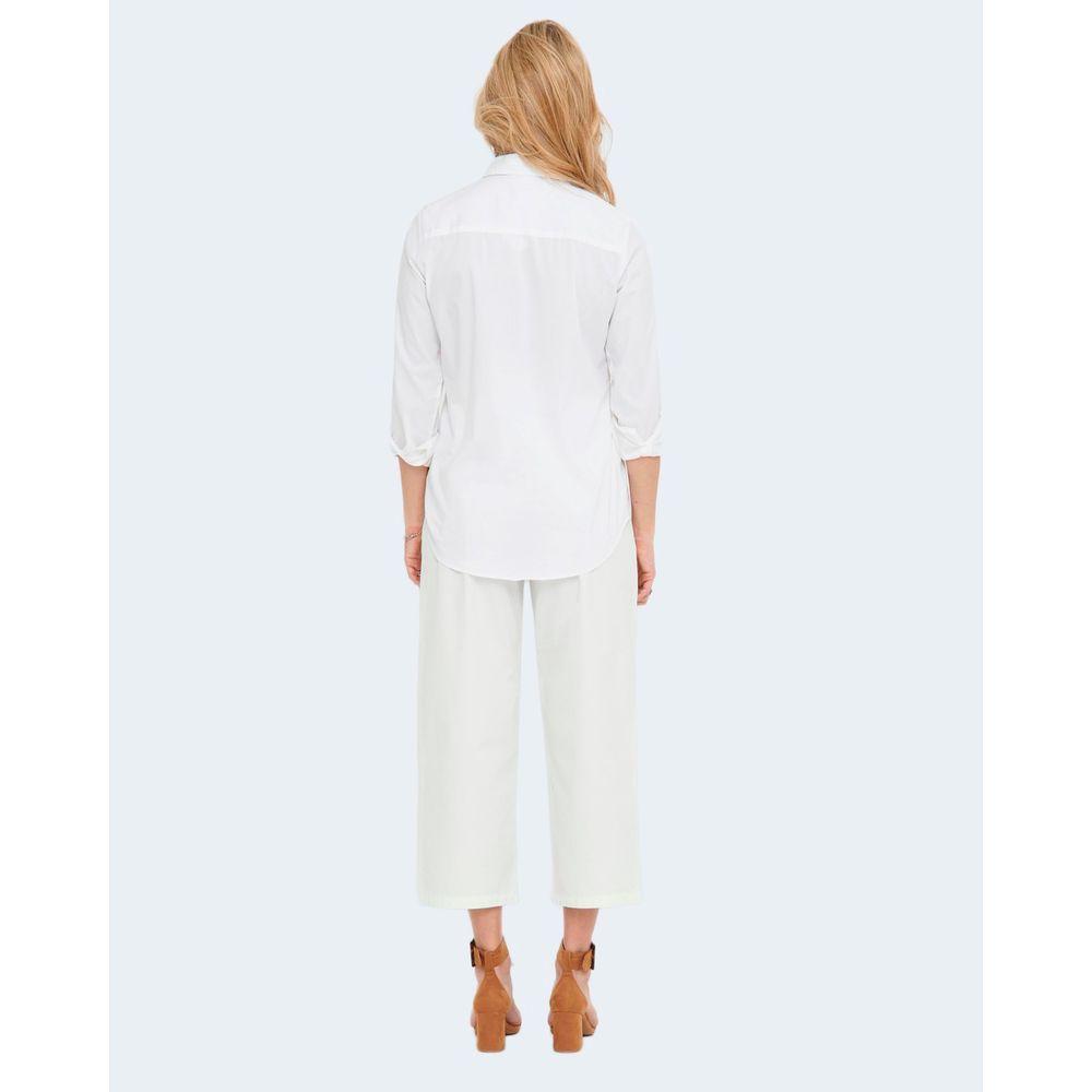 Back view of woman wearing a Jacqueline De Yong white cotton shirt, paired with white pants and brown heels, demonstrating elegant style.
