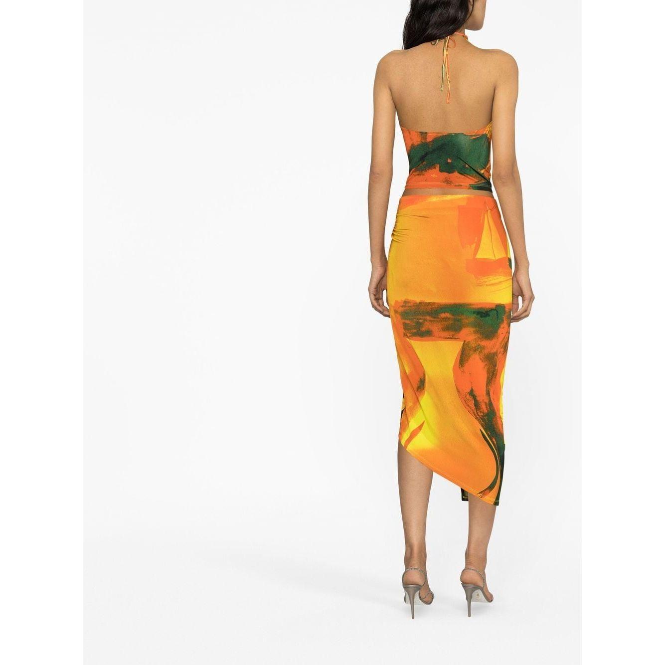 Back view of model in Louisa Ballou multicolour wrap skirt, featuring abstract pattern, asymmetric design, and ring hardware detailing.