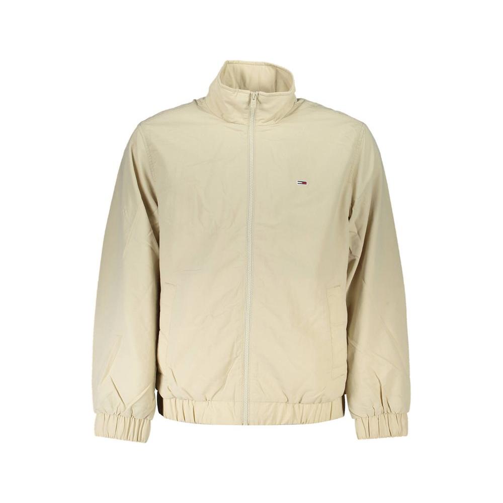Tommy Hilfiger beige men's jacket with zip closure, made from recycled nylon. Features elastic cuffs and waist, and iconic logo.