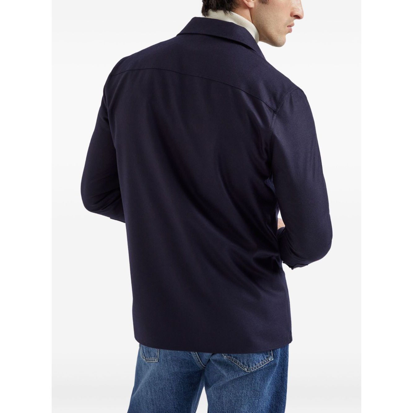 Rear view of a man wearing a Brunello Cucinelli Shirts Blue with long sleeves, chest flap pockets, and buttoned cuffs.
