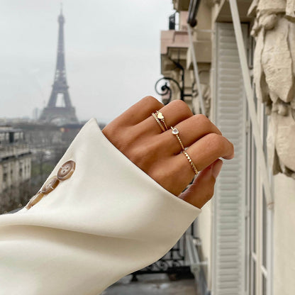 Elegant hand wearing 24KAE JEWELS JEWELRY Mod. 12417S/54 rings with Eiffel Tower in the background, Parisian style.