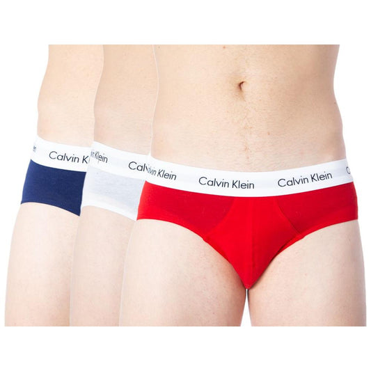 Three pairs of Calvin Klein men's hip brief underwear in red, white, and navy, featuring an elastic waistband with logo.