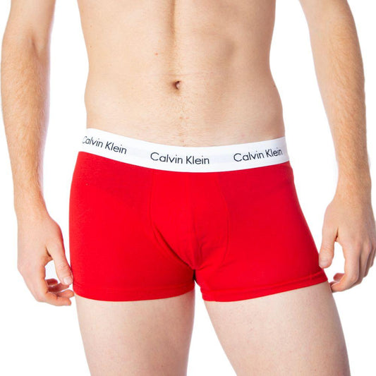 Model wearing red Calvin Klein men's boxer shorts with elastic logo waistband.