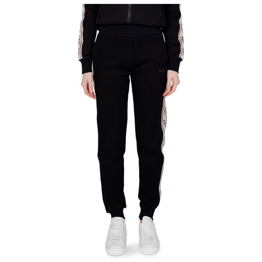 Model wearing Guess Active Britney Jogger sweatpants in black cotton, showcasing modern design and comfort with elastic waistband.