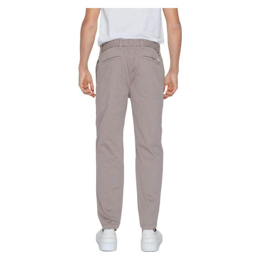 Back view of Hugo Boss brown men's tapered trousers, cotton-elastane blend, from the Spring/Summer collection, worn by a model.