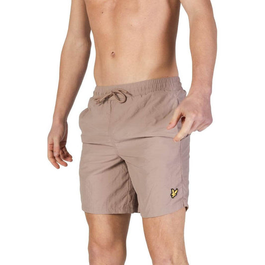 Man wearing Lyle & Scott gray nylon swimwear shorts, showcasing fall/winter men's bathing suit collection.