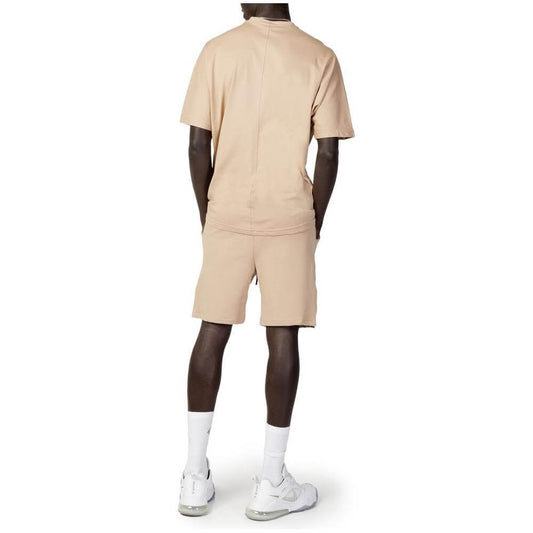 Rear view of a man wearing a beige Hydra Clothing cotton sweatsuit, part of the men's short suit collection for spring/summer.