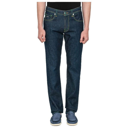 Man wearing Tramarossa blue cotton jeans with green stitching, regular fit, featuring a bright green suede patch and metallic logo.