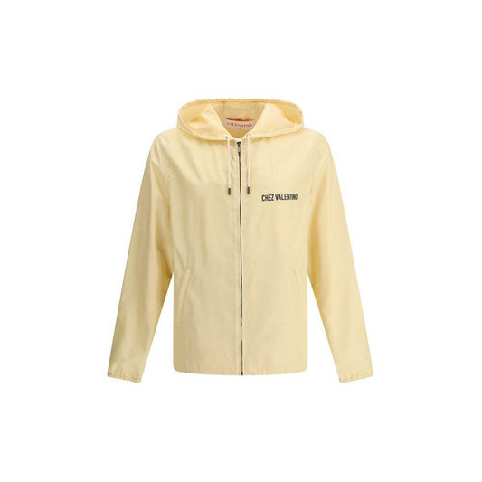 Valentino waterproof jacket with monogram, featuring a zipper closure, adjustable hood, and side pockets. Stylish and functional rain protection.
