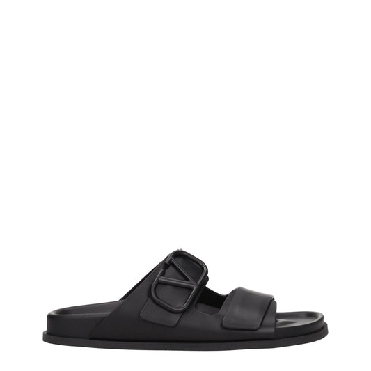 Valentino Garavani Black Leather Slippers with open toe and front logo, featuring a casual style and low flat heel.