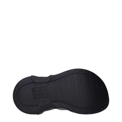 Bottom sole view of Givenchy Black Cotton Slippers, featuring a rubber sole with logo on the side and back, wedge heel, and round toe design.
