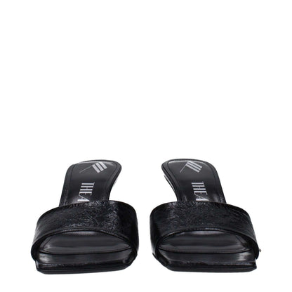 The Attico Black Leather Flat Sandals with vintage and aged effects, showing front view of elegant black footwear.