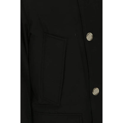 Close-up of Woolrich Black Cotton Parka with side patch pocket and button details, highlighting fabric and design features.
