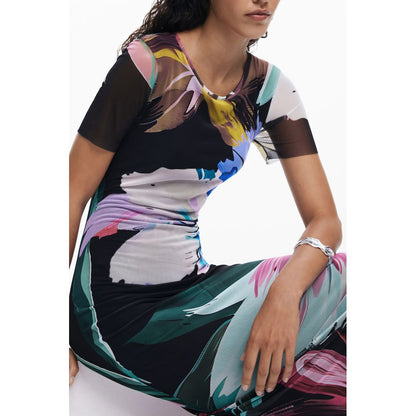 Woman wearing Desigual Black Polyester Women Dress with vibrant patterns and short sleeves.