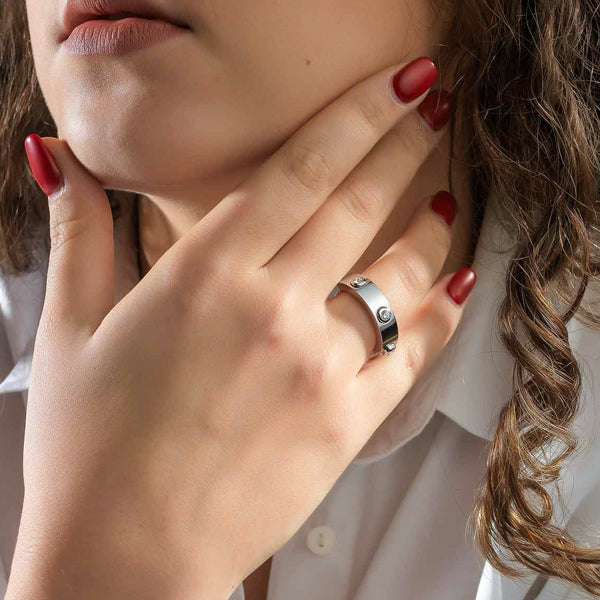Close-up of a hand wearing AN JEWELS JEWELRY Mod. AL.RWH01SC-8 ring with red nails and white shirt sleeve.