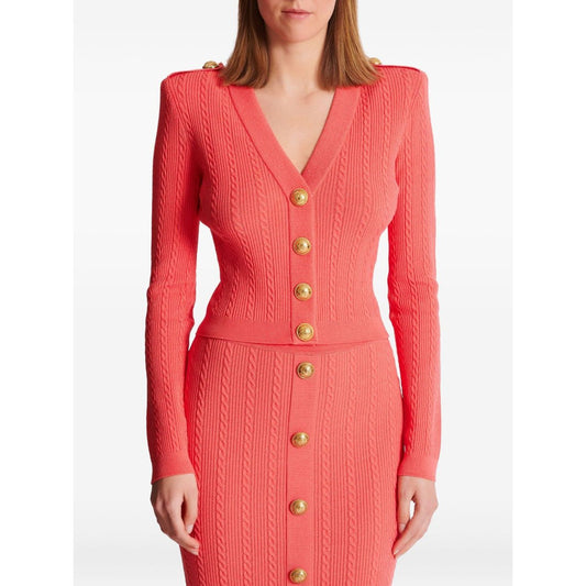 Coral pink Balmain long-sleeved twisted knit cardigan with gold logo-embossed buttons and plunging V-neck.