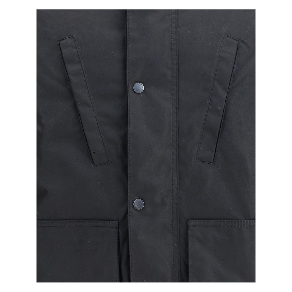 Close-up of Barbour International Black Cotton Parka showing front pocket details and button closure.
