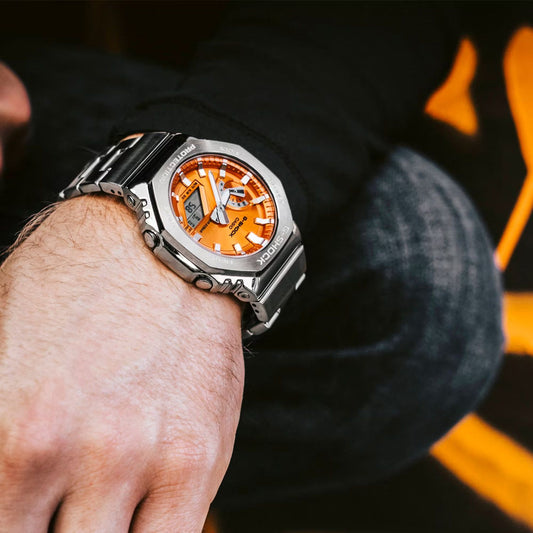 Gent wearing CASIO G-SHOCK Mod. OAK G-STEEL VIVID ORANGE wristwatch with SS & Resin case and strap, showcasing multifunction quartz design.