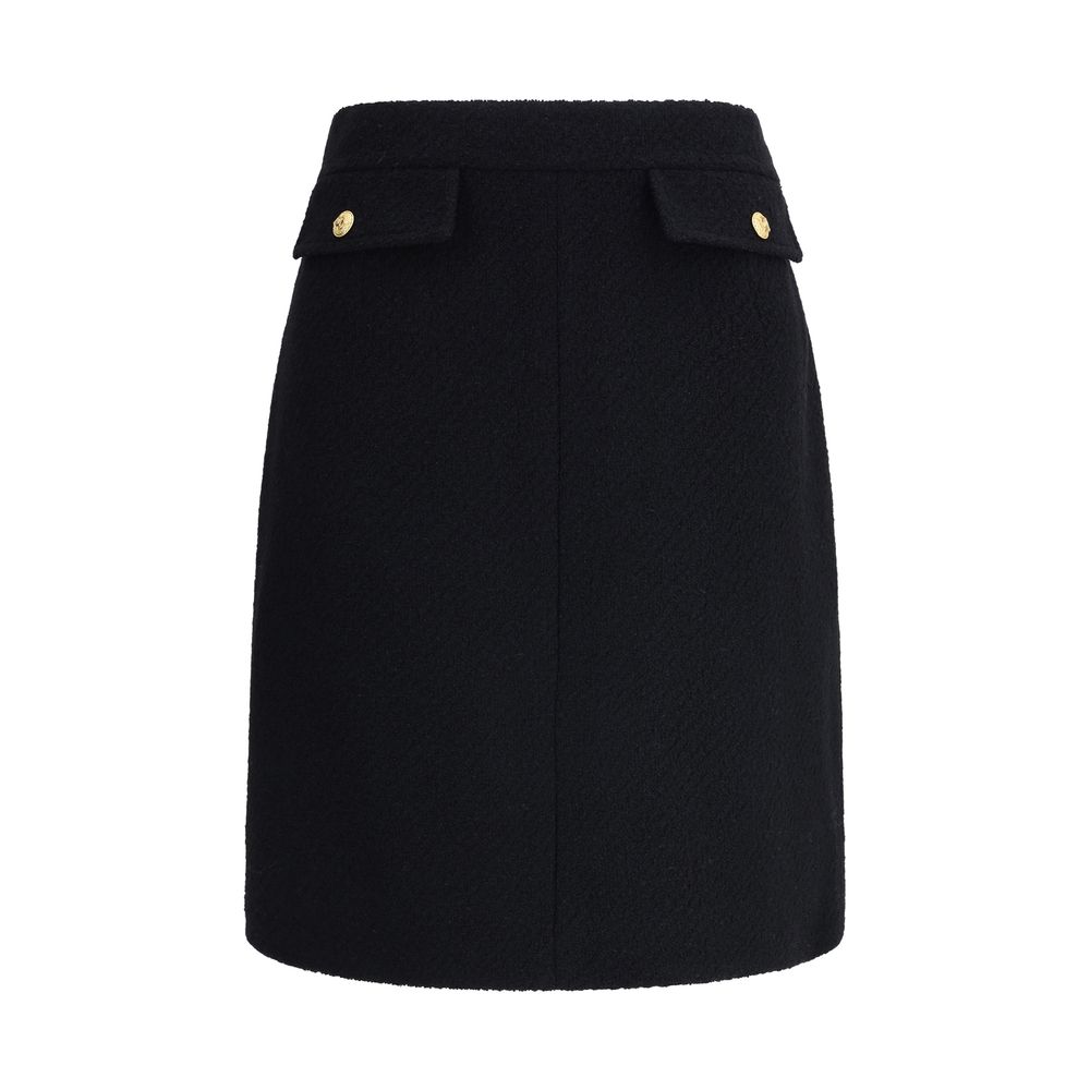 Chloé Black Wool Midi Skirt with front flap pockets and gold-tone buttons, crafted from bouclé wool for a structured fit.