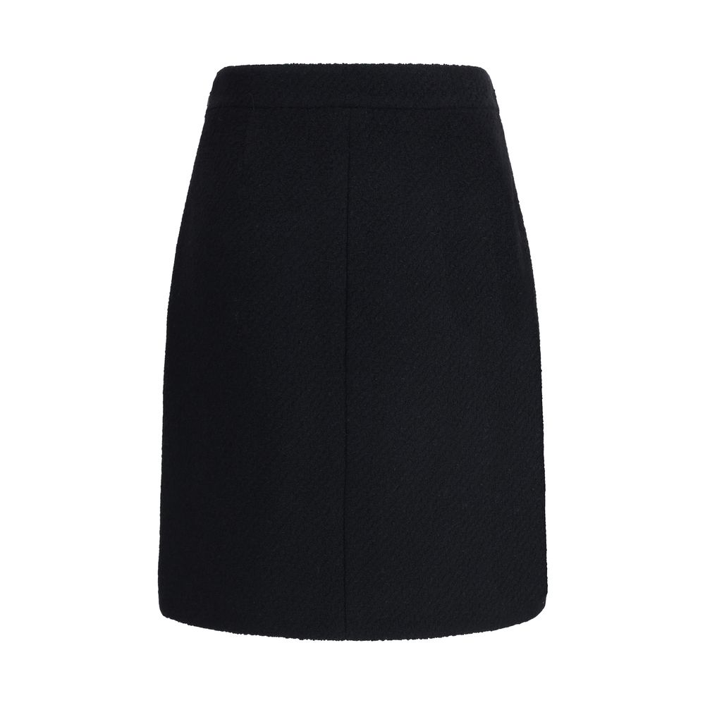 Chloé Black Wool Midi Skirt with bouclé texture, front flap pockets, and gold-tone button accents, designed for an elegant, structured silhouette.