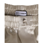 Dolce & Gabbana Beige Silk Satin Elastic Men Boxer Short Swimwear with button detail and logo on waistband.