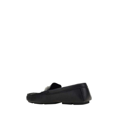 Dolce & Gabbana Black Rubber Slip-On Loafers with calfskin upper and metal monogram plaque, side view showing non-slip sole.