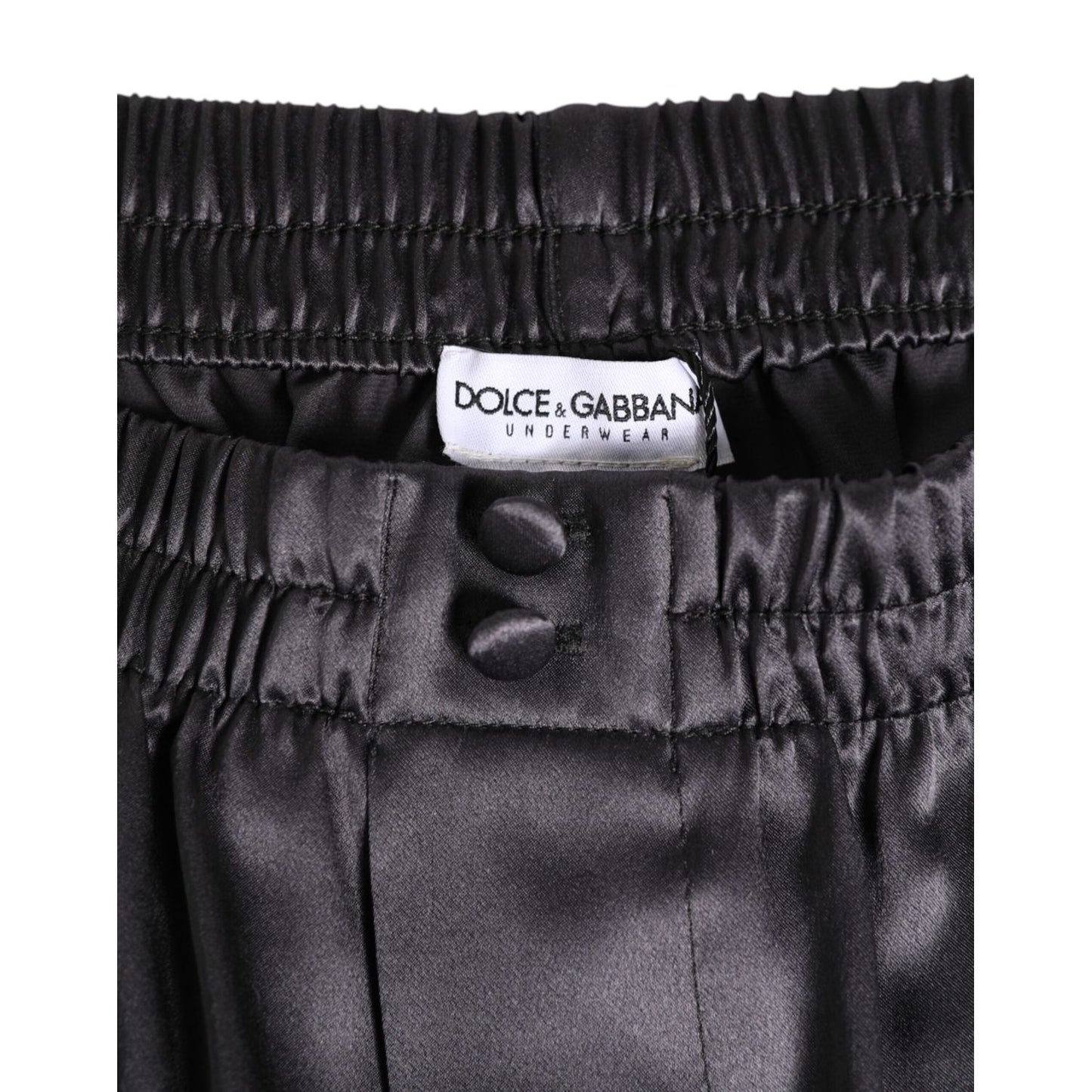 Dolce & Gabbana Black Satin Silk Elastic Men Boxer Short Swimwear waistband close-up with logo and button details.