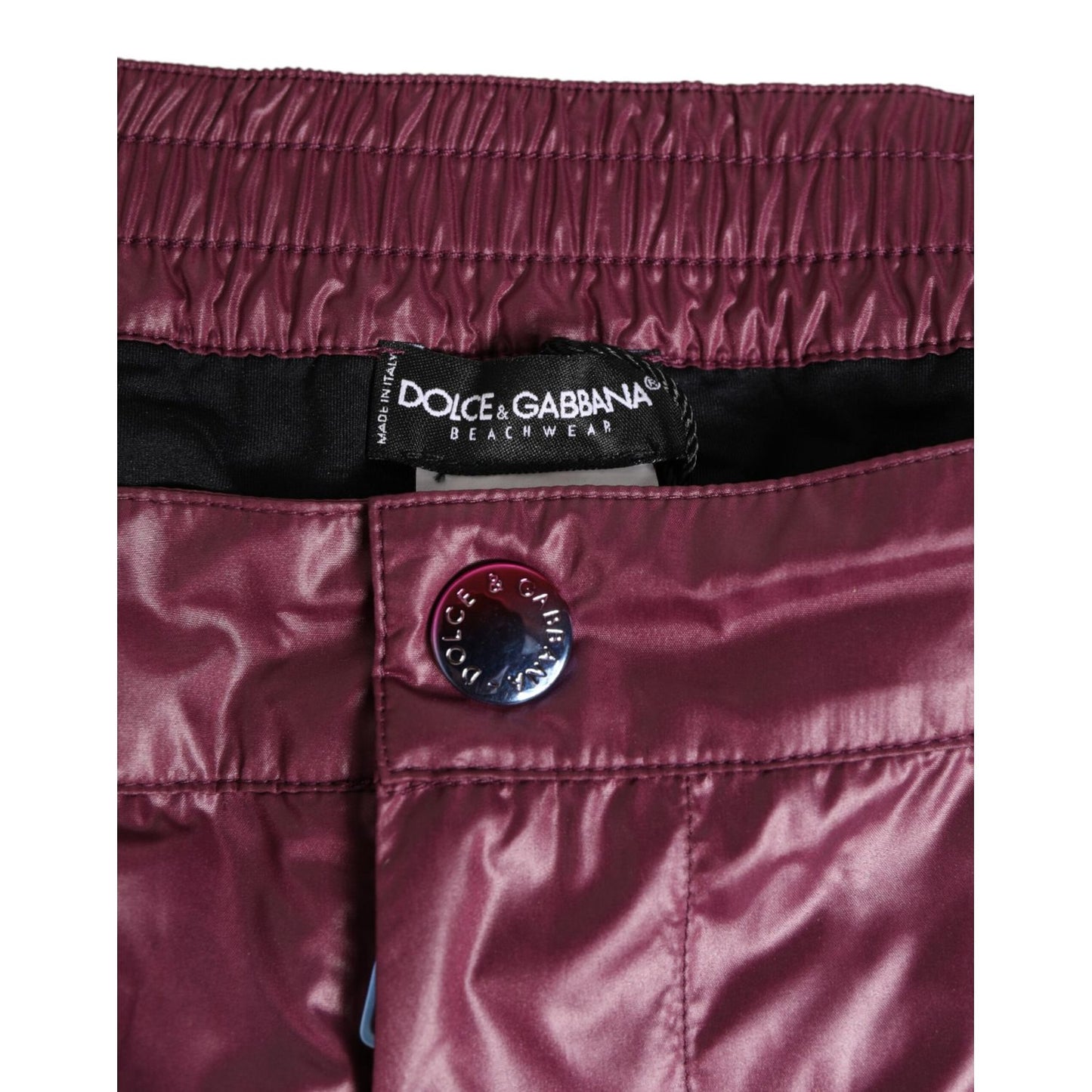 Dolce & Gabbana Burgundy Polyester Logo Embossed Crest Swimwear with glossy finish and embroidered crest detail.