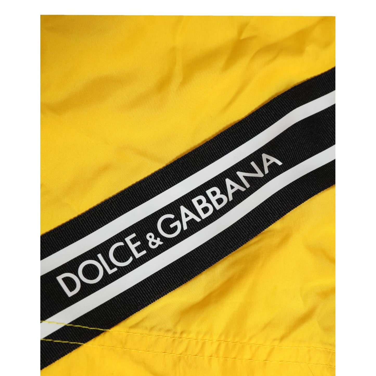 Close-up of Dolce & Gabbana Yellow Drawstring Beachwear Men Shorts Swimwear featuring logo detail.