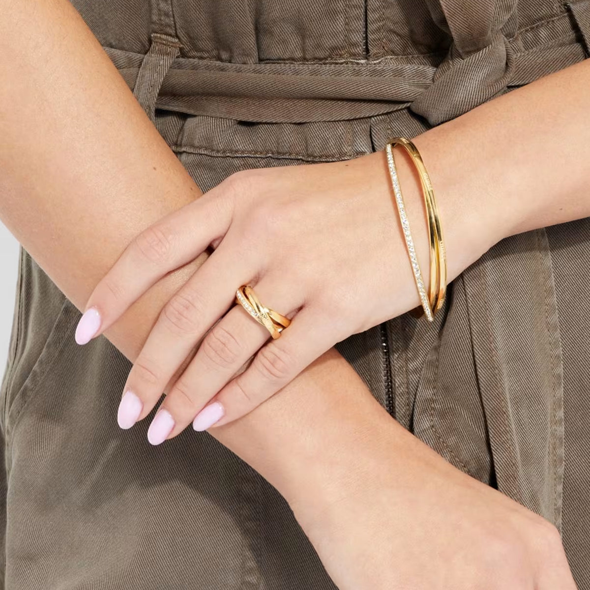 Alt Tag: Stylish woman wearing GUESS JEWELS JEWELRY Mod. JUBR04067JWYG56 with gold bracelet and ring on wrist.