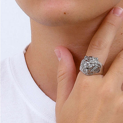Lion head ring on finger with white t-shirt background, highlighting jewelry details.