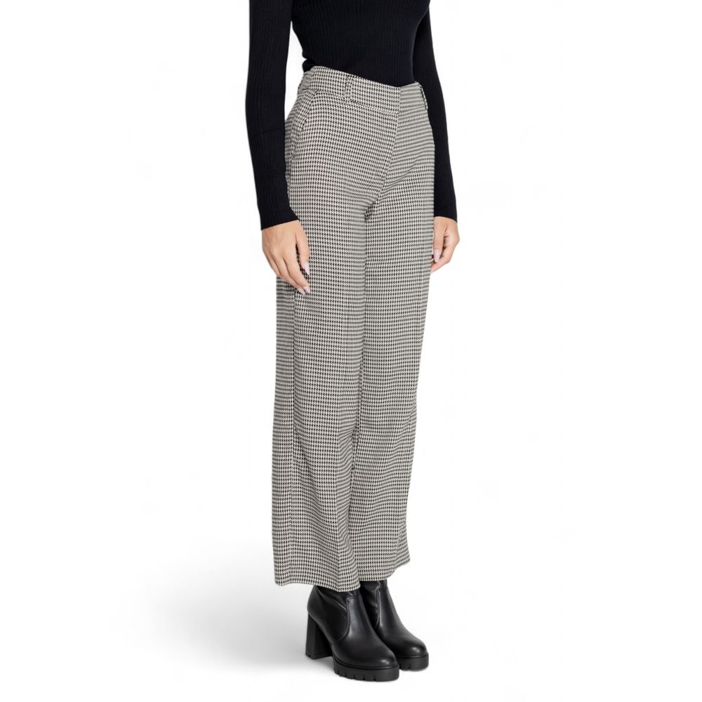 Model wearing houndstooth wide-leg pants with black top and shoes.