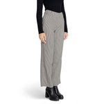 Model wearing houndstooth wide-leg pants with black top and shoes.